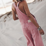 Woman wearing pink wide-leg overalls, full outfit