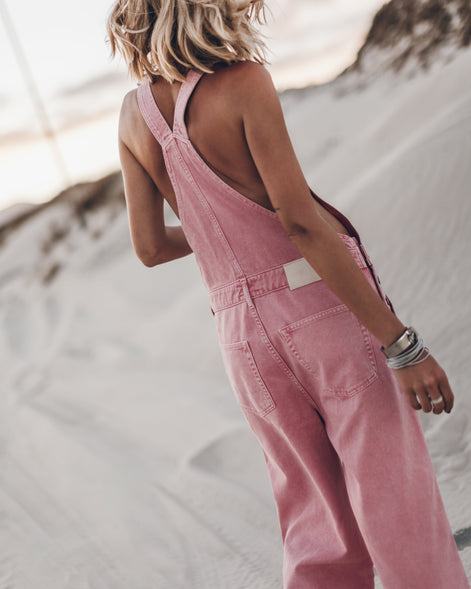 Woman wearing pink wide-leg overalls, full outfit