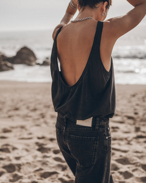 Woman wearing dark low back tank top at the beach